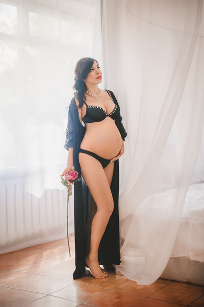 raskaana oleva nainen mustissa alusvaatteissa
 - Valokuva, kuva