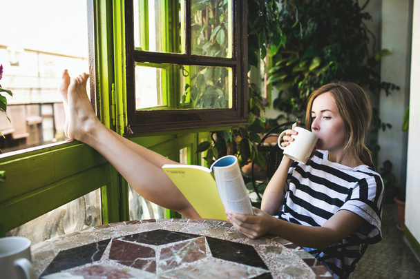Woman drinking coffee and reading book - Zdjęcie, obraz