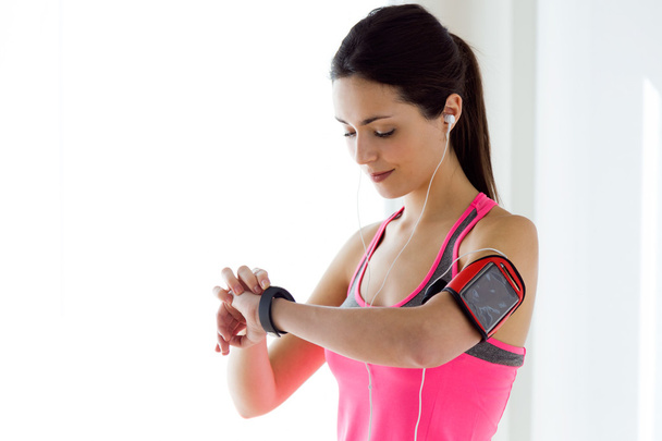 Young fitness woman looking at her smart watch while taking a br - Foto, imagen