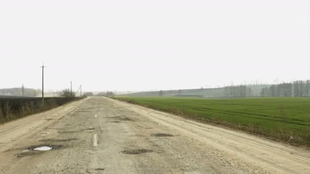 Rural destroyed asphalt road in calm countryside. Springtime landscape. - Footage, Video