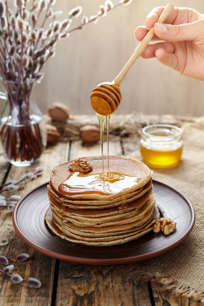 Flowing honey on stack of traditional american pancakes - Foto, afbeelding
