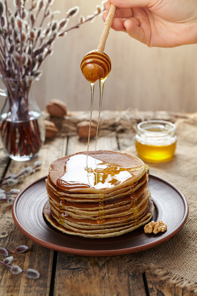 Woman flowing maple syrup on stack of traditional pancakes - Φωτογραφία, εικόνα
