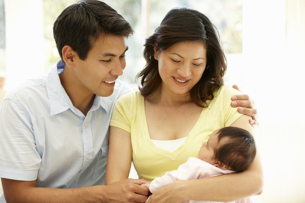 Happy couple holding their baby - Foto, imagen