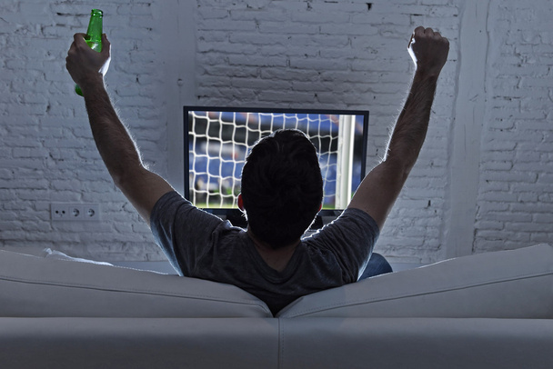 νεαρός άνδρας σπίτι μόνο βλέποντας ποδόσφαιρο ή το ποδόσφαιρο παιχνίδι στην τηλεόραση απόλαυση και από τον στόχο  - Φωτογραφία, εικόνα