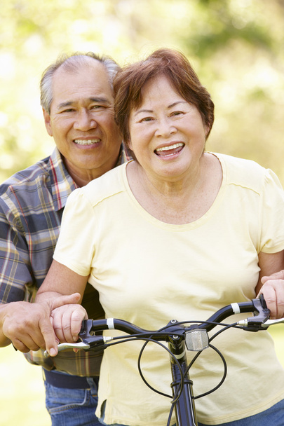 Senior couple both sitting on one bike - Photo, image