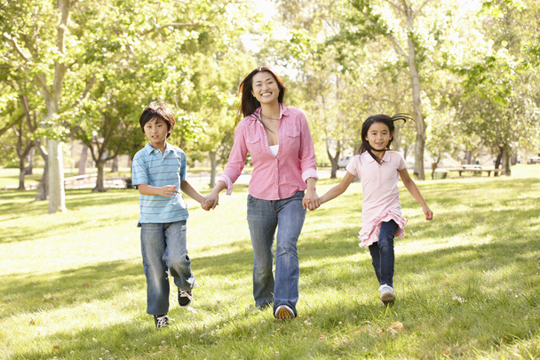 Mother and children running in park - 写真・画像