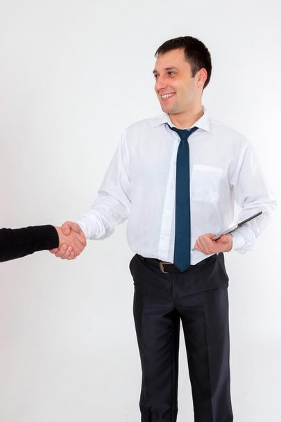 Successful young businessman shaking hands on a light background - Photo, Image