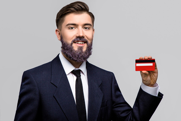 Hymyilevä mies poseeraa punaisella luottokortilla
 - Valokuva, kuva