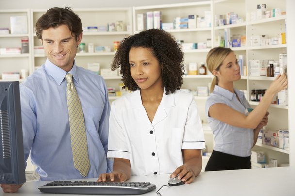 Pharmacists working on computer in pharmacy - Photo, image