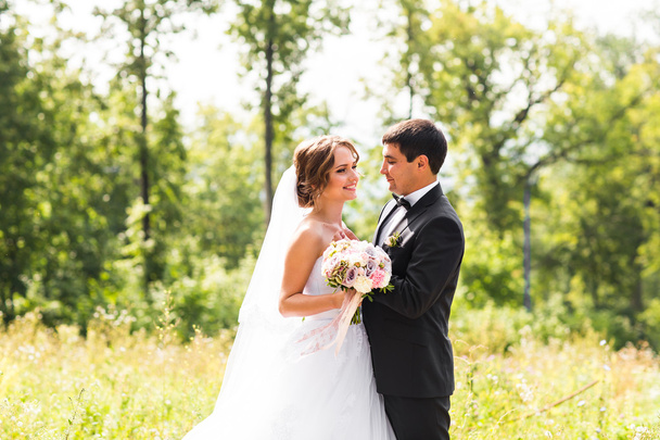 Jeune couple de mariage profitant de moments romantiques à l'extérieur sur une prairie d'été
 - Photo, image