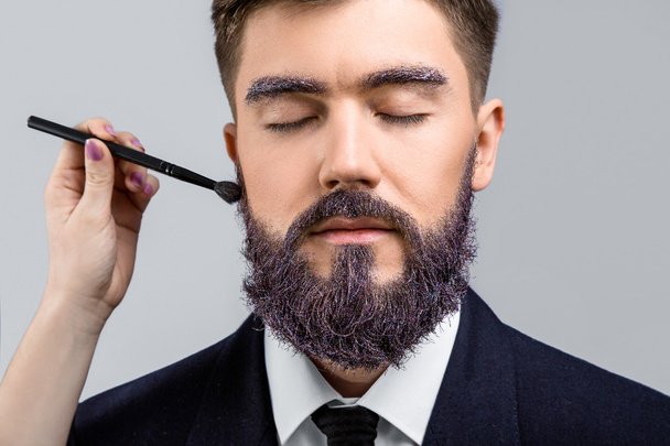 Brunette man met make-up borstel - Foto, afbeelding