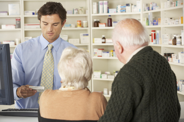 Pharmacist with senior couple in pharmacy - Foto, Imagem