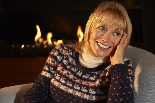 Woman relaxing in front of fire - Photo, Image