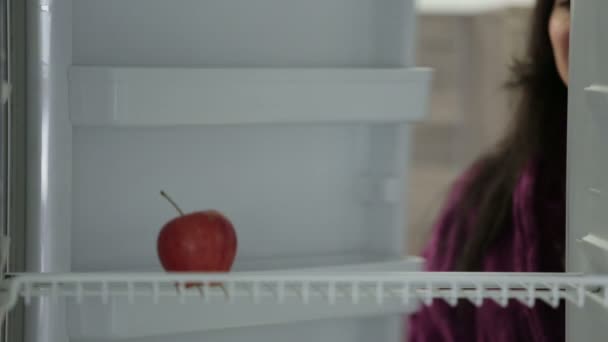 woman taking apple from fridge  - Materiał filmowy, wideo