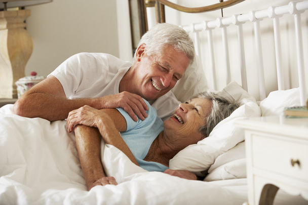 Happy Senior Couple In Bed Together - 写真・画像