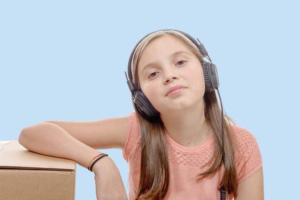  プレティーン ヘッドフォン、青い背景で音楽を聴く - 写真・画像