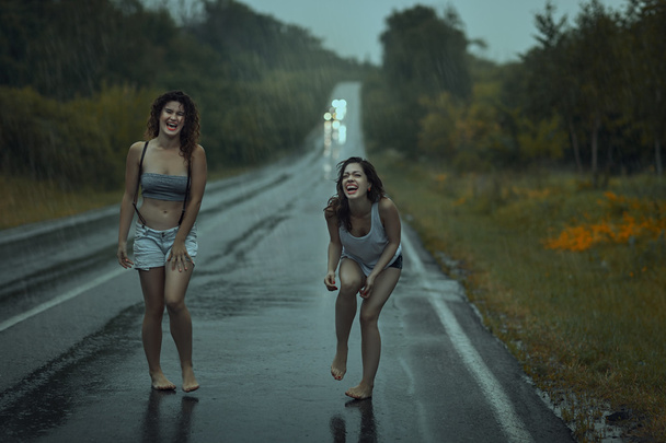 Женщины шалят на дороге. - Фото, изображение