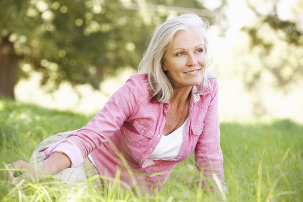 Senior Woman Relaxing In Sunny Field - Photo, Image