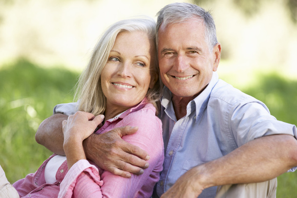 Senior Couple Relaxing In Sunny Field - Photo, image