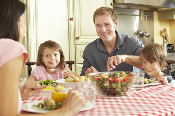 Family Eating Meal Together In Kitchen - Foto, Imagen