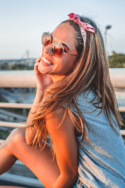 Улыбающаяся девушка позирует на мосту
 - Фото, изображение