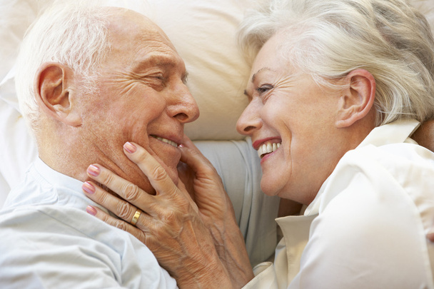 Senior Couple Relaxing In Bed - Фото, зображення