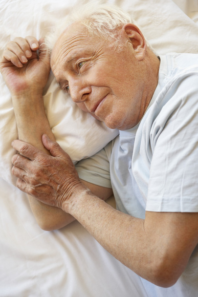 старший чоловік розслабляється в ліжку
 - Фото, зображення