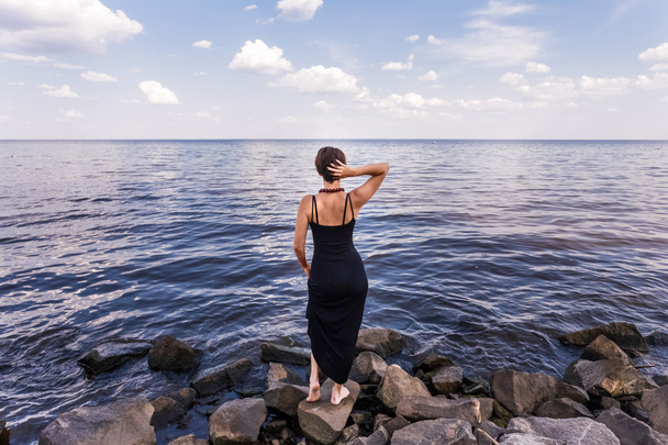 Lány állni magozott folyó partján a háttérégbolt - Fotó, kép