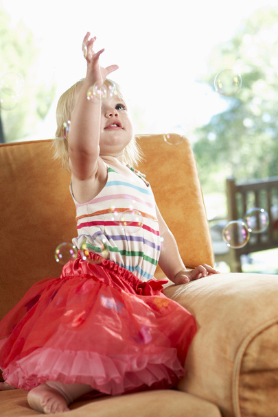 Girl Playing With Bubbles On Sofa - Zdjęcie, obraz