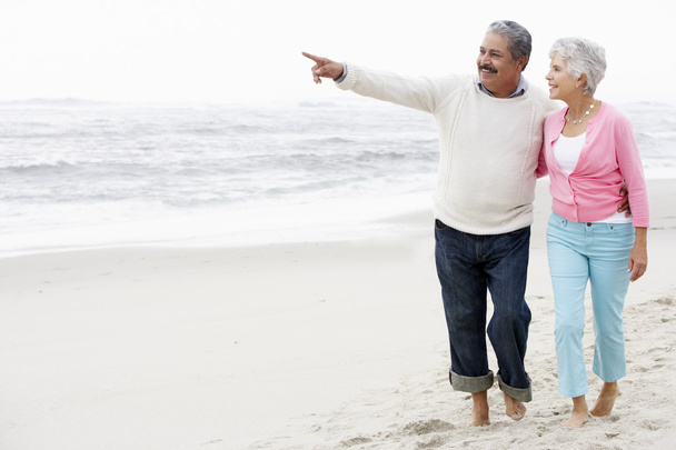 Senior Couple Walking Along Beach - Фото, зображення