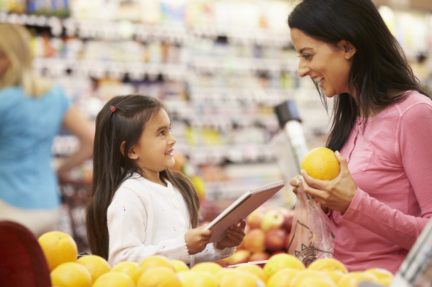 Mother And Daughter In Supermarket - Foto, afbeelding