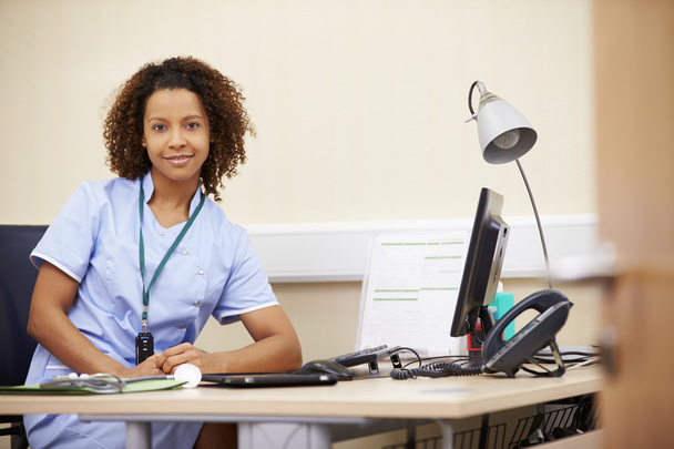 Female Nurse Working At Desk In Office - Photo, Image
