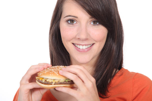 Young woman eating burger - 写真・画像