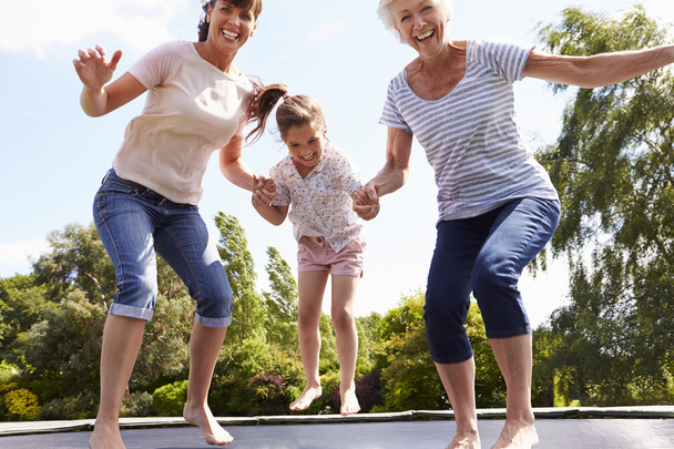 Grandmother, Granddaughter And Mother On Trampoline - Foto, immagini
