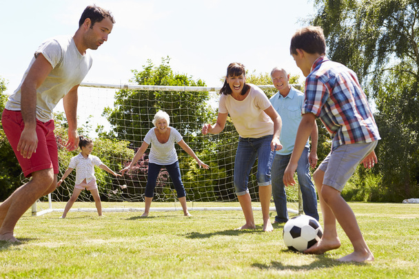 Multi Generation Playing Football In Garden - Фото, изображение