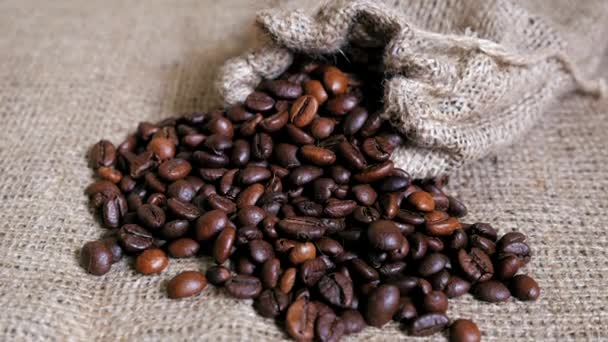 Coffee beans spilled from pouch on sackcloth. Dolly shot. - Video, Çekim