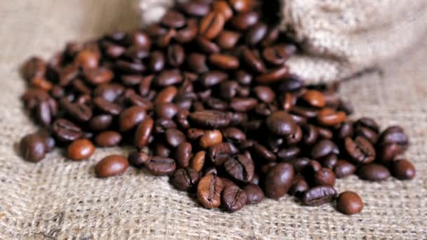 Coffee beans spilled from pouch on sackcloth. Dolly shot. - Video, Çekim