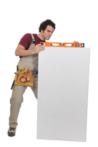 Carpenter with a spirit level and blank board - Фото, зображення