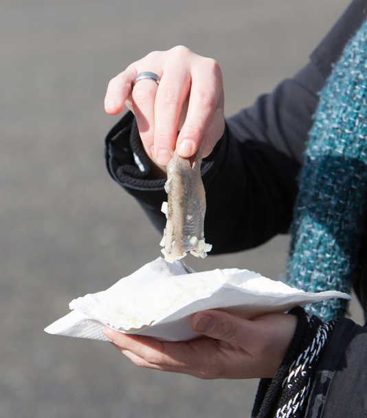 Donna olandese sta mangiando aringhe crude tipiche
 - Foto, immagini