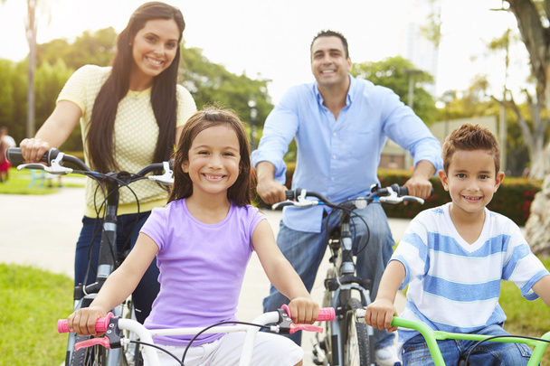 Parents With Children Riding Bikes In Park - Foto, immagini