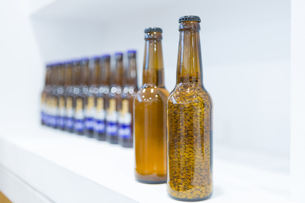 Bottiglie di vetro pieno su scaffale bianco
 - Foto, immagini