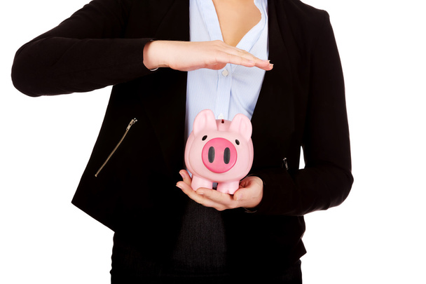 Young business woman protects piggybank. - Foto, Bild