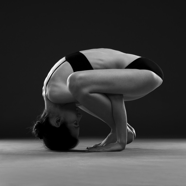 Yoga asana. Beautiful sexy body of young woman on black background - Foto, Imagem