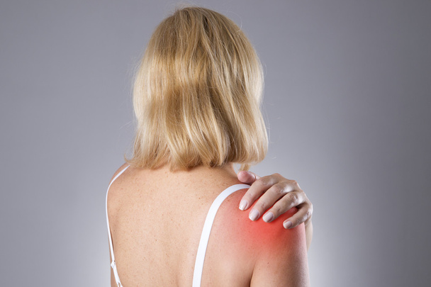 Woman with pain in shoulder. Pain in the human body - Foto, afbeelding