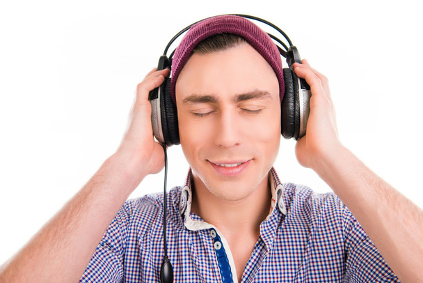 Happy man in violet cap listening music with closed eyes - Фото, зображення