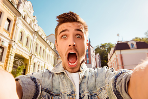 Handsome man making selfie and grimacing with opened mouth - Foto, Bild