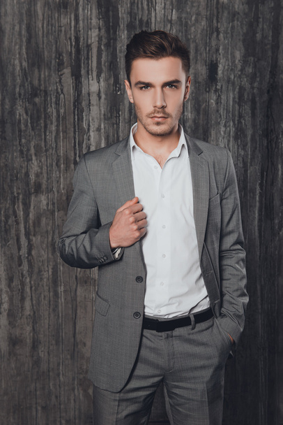 Portrait of handsome businessman in suit holding hand in pocket - Photo, Image