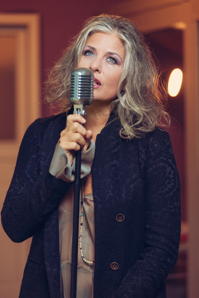 Woman with microphone sing in interior - Photo, image