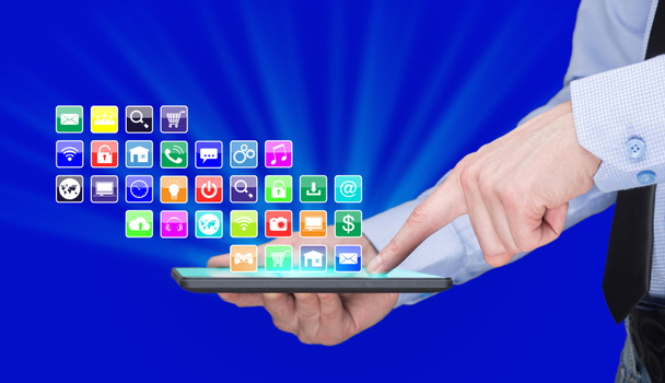 Empresario sosteniendo una PC tableta con iconos de aplicaciones móviles en la pantalla virtual. Concepto de Internet y negocios
. - Foto, imagen