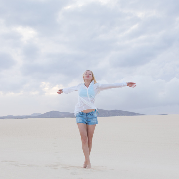 Беззаботная женщина наслаждается свободой на пляже
. - Фото, изображение